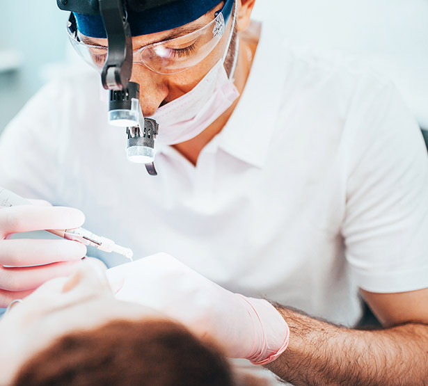 Un chirurgien dentiste effectue des soins sur son patient | MACSF