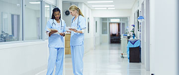 Deux agents hospitaliers discutent du dossier d'un patient | MACSF